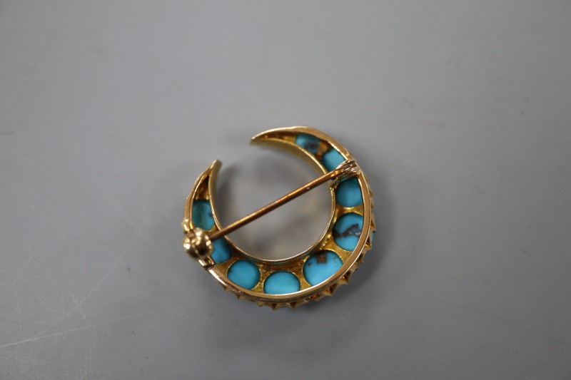 A Victorian style yellow metal and graduated turquoise set crescent brooch, 24mm, gross 5.3 grams.